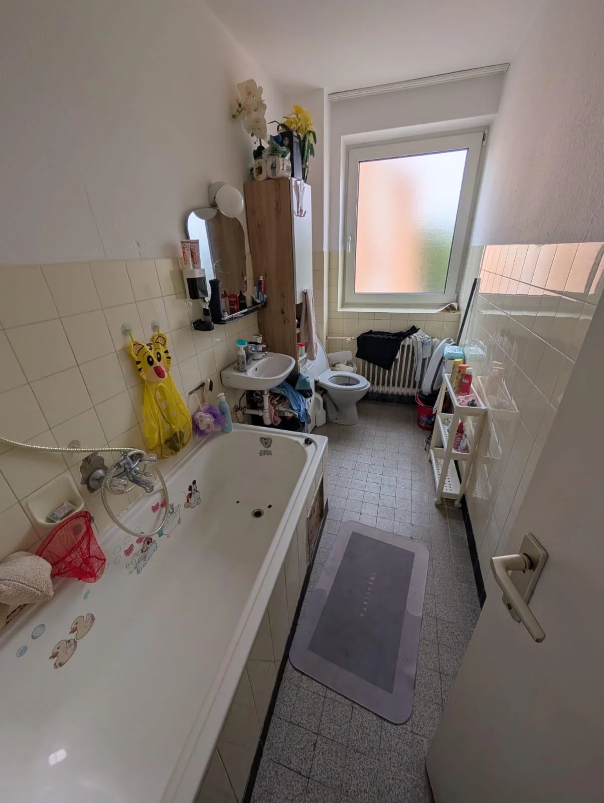 Bestehendes schmales Badezimmer mit Badewanne und Fenster an der Stirnseite