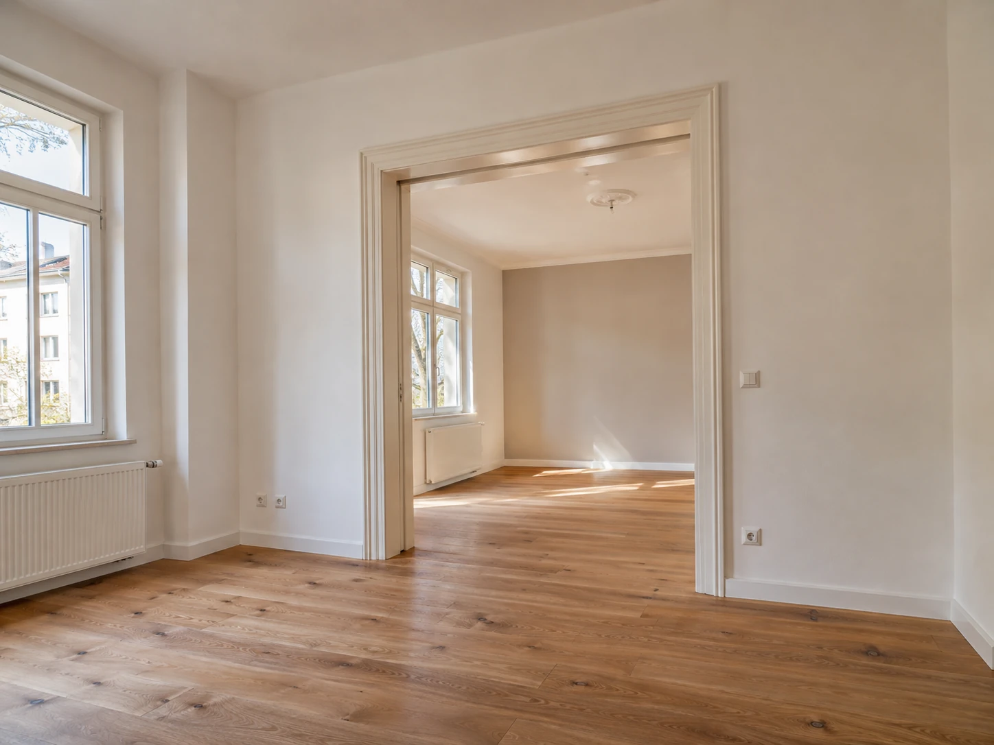 Blick durch eine Tür in helle sanierte Wohnräume mit Eichenboden